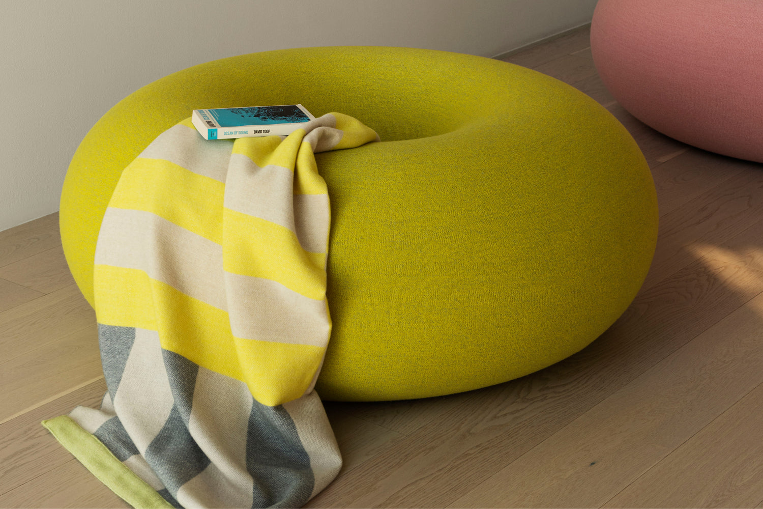 A lifestyle image of a lounge scene featuring Boa Pouf in Sulfur Yellow.