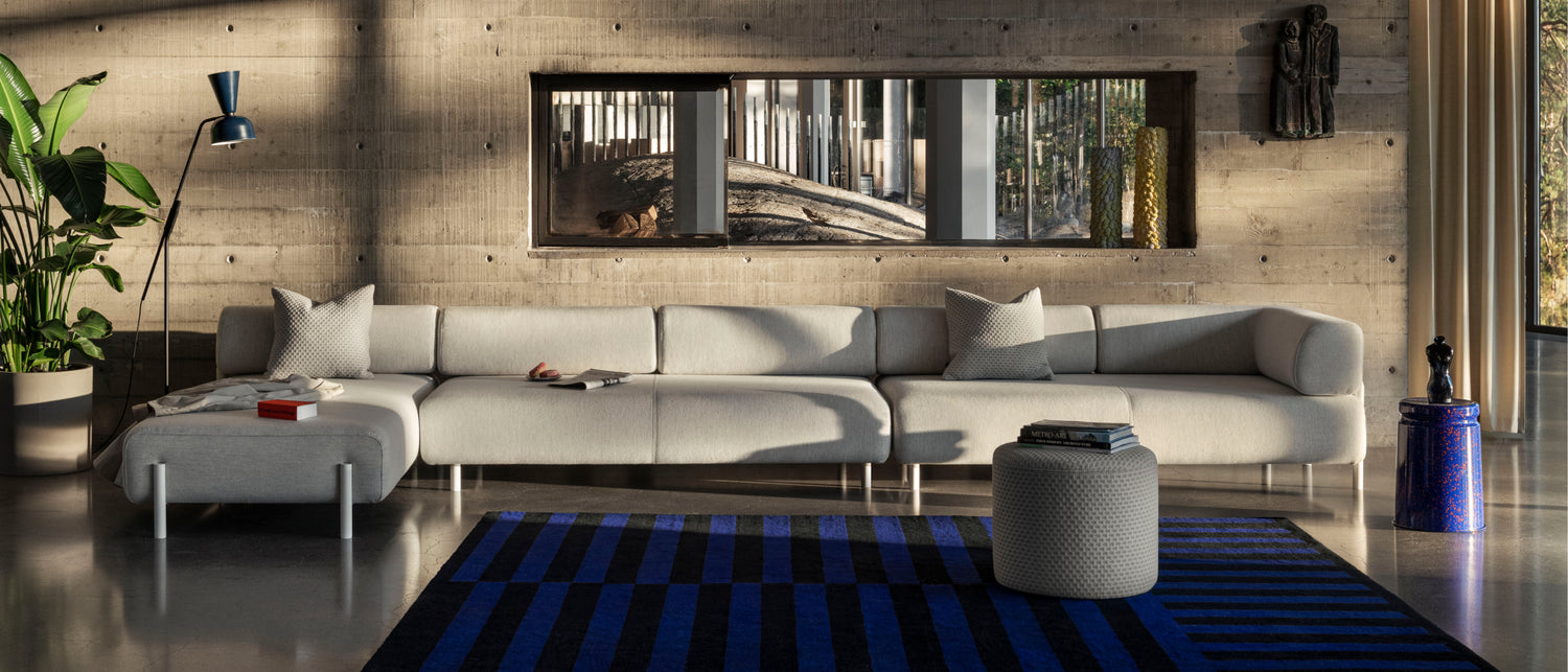 Hem - A living room scene featuring Alphabeta Floor Lamp, Stripe Rug Large, Palo Modular Sofa, Bon Pouf Round, Last Stool, and Dash Cushions.