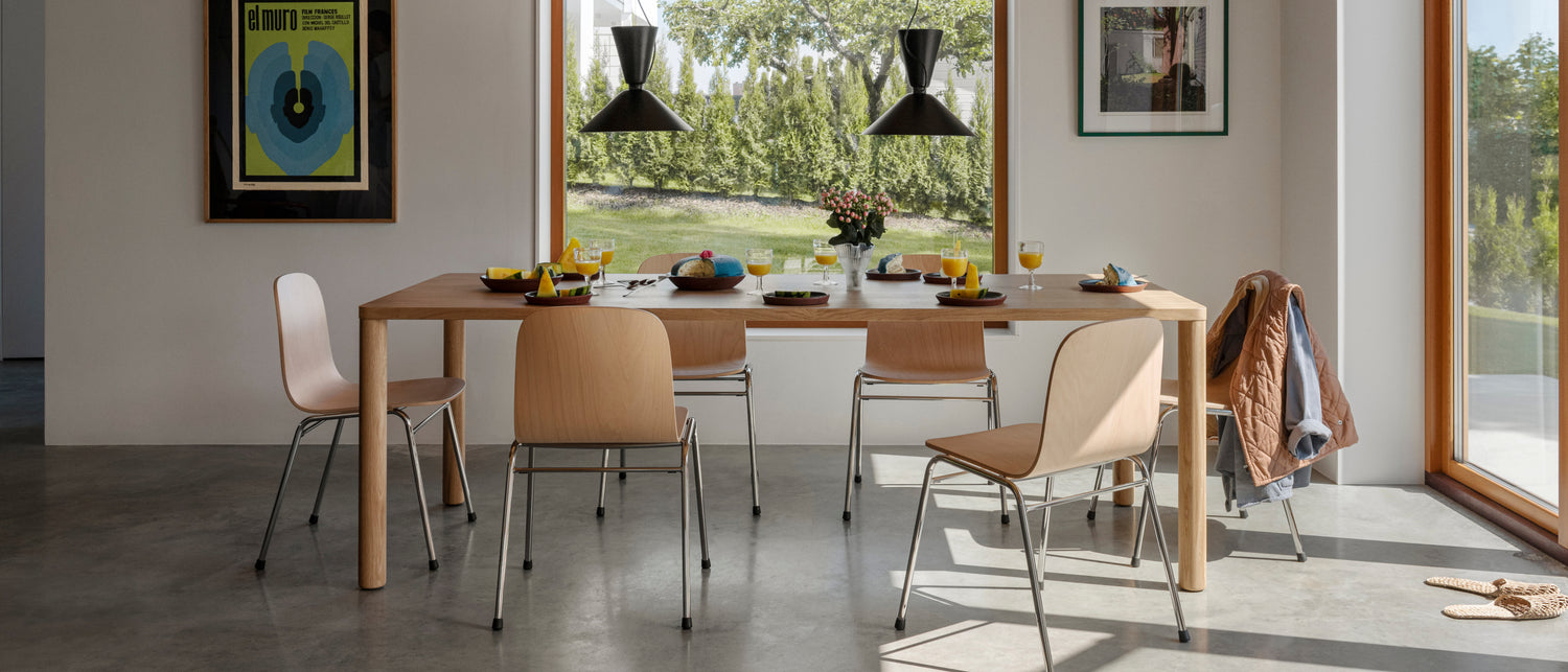 A lifestyle image of a dining scene featuring Log Table, Alphabeta Pendant Light, and Touchwood Chair.