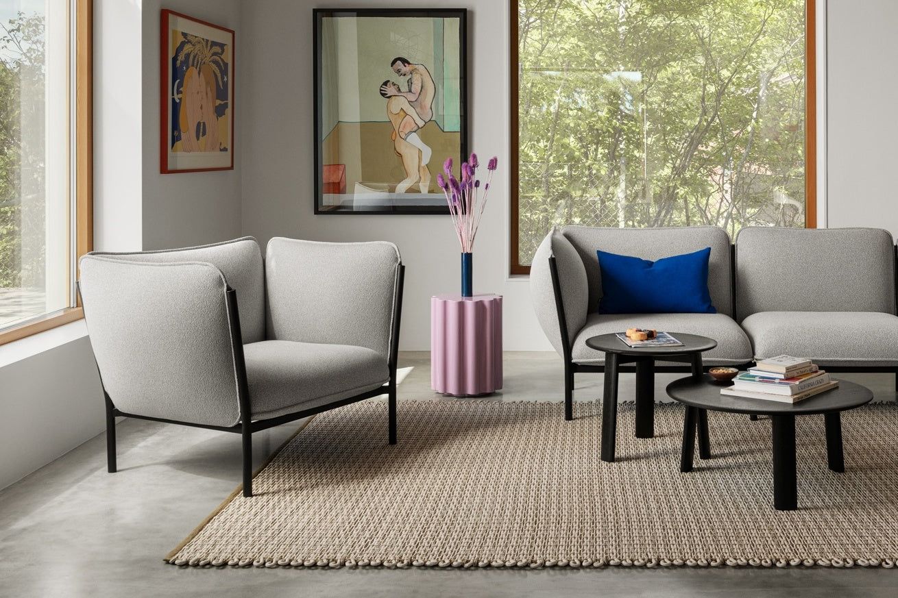 A living room scene featuring a Rope Rug, Alle Coffee Tables Set of 2 Black, Kumo Single Seater + Armrests in Porcelain, and a Kumo Sofa in Porcelain.