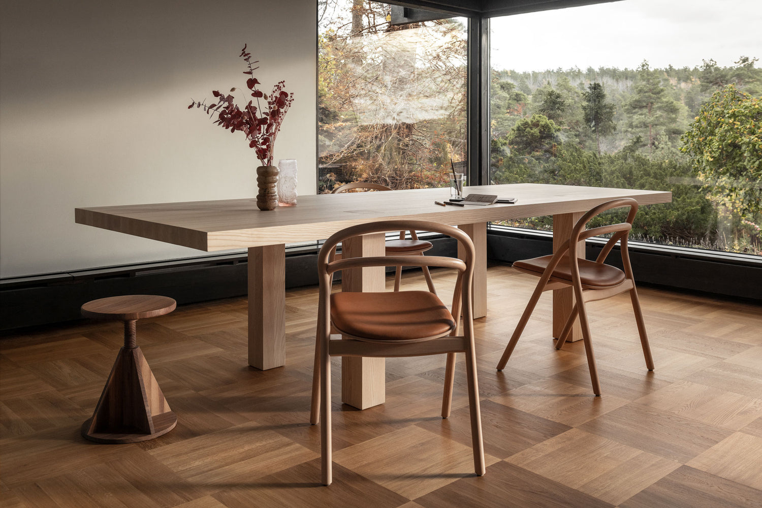 A dining room scene featuring Max Table, All Wood Stool Rocket in Walnut, and 2 Udon Upholstered Chairs in Natural / Cognac Leather.