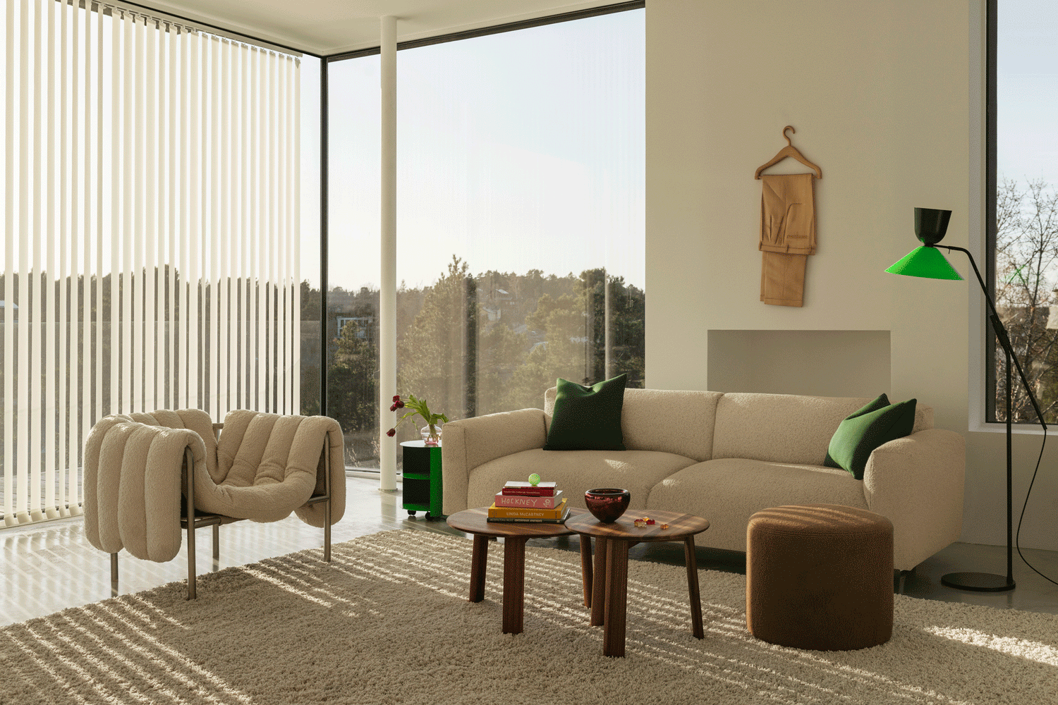 A living room scene featuring Puffy Lounge Chair Eggshell / Stainless Steel, Hide Side Table Pure Green, Koti 3-seater Sofa, Alle Coffee Tables Set of 2 Walnut, Bon Pouf Round Brown and an Alphabeta Floor Lamp.